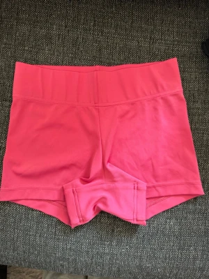 Rosa träningstights shorts från Adidas - Säljer ett par rosa träningstights shorts från Adidas. De är högmidjade och har en tight passform med bred linning för extra stöd. Perfekta för gymmet eller andra sportaktiviteter. Materialet är mjukt och stretchigt för maximal rörelsefrihet.  Skriv privat för fler bilder eller om du har några frågor💗