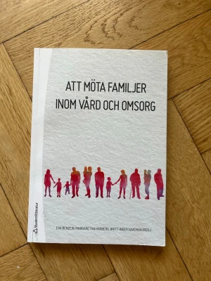 Att möta familjer inom vård och omsorg - Kursbok med vit framsida och illustration av familjer i rött och lila. Titeln är 'Att möta familjer inom vård och omsorg'. Boken riktar sig till studenter inom vård och omsorg och tar upp familjeperspektiv vid sjukdom och hälsa. Andra upplagan.
