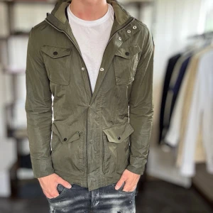 Grön field jacket - Mycket fint skick, dragkedjan fungerar inte tyvärr men den går att knäppa från topp till botten så gör inte så mycket. Nypris ca 3000kr. Passar dig som är 170-180cm ungefär. Modellen är 185 cm, 75 kg. Alltid billigare pris vid köp av flera varor‼️🙌Svarar alltid på frågor eller funderingar! 