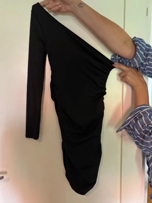 Svart oneshoulder klänning - Klänningen är helt oanvänd.
