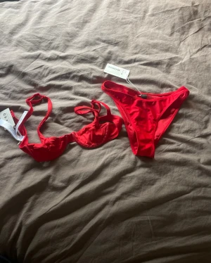Röd bikini överdel & underdel  - Säljer en jättefin röd bikini, både underdel och överdel. Säljer då färgen inte riktigt var min smak och den var för liten. Helt oanvänd, endast testad en gång! Bikiniöverdelen storlek 70B, underdelen storlek S. Postar inom 1-2 dagar, oftast samma dag <3