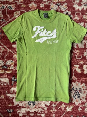 Abercrombie & Fitch T-shirt grön , New York - Grön T-shirt från Abercrombie & Fitch med på sydd logga framtill   Storlek: M  Längd: 68cm Axelbredd: 38cm  Hör av dig vid frågor eller funderingar!  kolla gärna in min profil för liknade kläder.