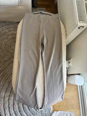 Beige yogapants med bootcut - Säljer ett par stilrena beige mjukisbyxor med bootcut. Byxorna har en enkel design utan synliga fickor eller loggor och är gjorda i ett mjukt, stretchigt material som känns skönt mot huden. Perfekta för chill dagar eller när du vill vara bekväm.