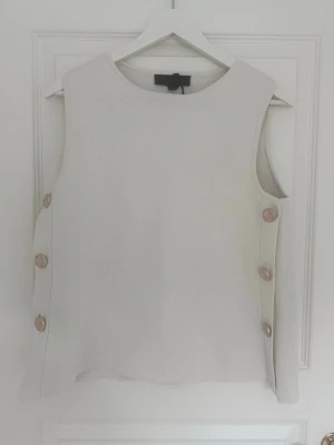 Vit stickad topp med knappar - En krämvit stickad topp från Zara. Den är mer åt krämbeige/vita hållet. 