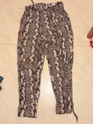 Ormmönstrade byxor  - Säljer ett par snygga leggings med ormmönster. Passar bra till sommaren nu!!