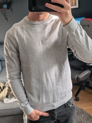 Ljusgrå bläck  sweatshirt - En stilren ljusgrå sweatshirt med rund halsringning och ribbade muddar vid ärmslut och nederkant. Tröjan har en enkel och clean design, perfekt för en avslappnad look. Tillverkad i mjukt material som känns skönt mot huden. Tröjan är från bläck och är helt oanvänd 