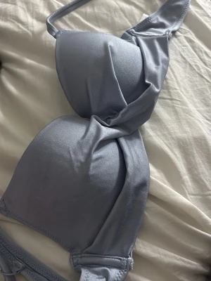 Ljusblå bikini över del - Snygg ljusblå bikini bh. Bh:n har justerbara axelband och klassisk knäppning bak. Storlek 75a inte push up.