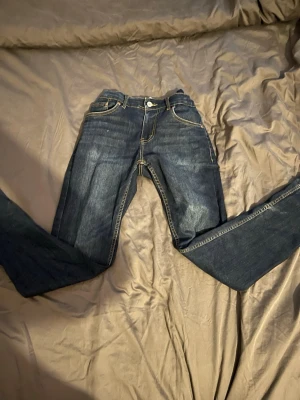 Mörkblå Levis jeans - Säljer ett par mörkblå Levis jeans med raka ben och kontrastsömmar. Klassisk femficksmodell med knapp och dragkedja framtill. Perfekta till vardagslooken och lätta att matcha med olika stilar.