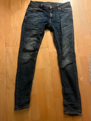 Nudie jeans - Säljer ett par mörkblå jeans från nudie i storlek 29/30.Jeansen är i passform slim/skinny och har inga defekter eller fläckar på sig.