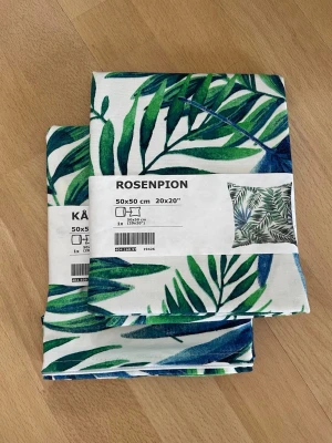 Två helt nya och oanvända kuddfodral med blad - Två helt nya/oanvända kuddfodral till prydnadskuddar i serien rosenpion från Ikea. De har kvar originalomslag runt, den ena hade dock ett omslag från en annan serie när jag köpte den (se bild 5), men det är fortfarande samma kuddfodral! De är lite grövre i materialet (se bild 2) och har väldigt fin och klar färg!