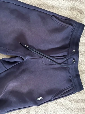 Mörkblå Ralph Lauren shorts - Snygga mörkblå mjukisshorts med två fickor fram samt en bakficka. Byxorna har en broderad logga på ena benet och är gjorda i mjukt sweatshirtmaterial. Perfekta för chill dagar eller när du vill vara bekväm.
