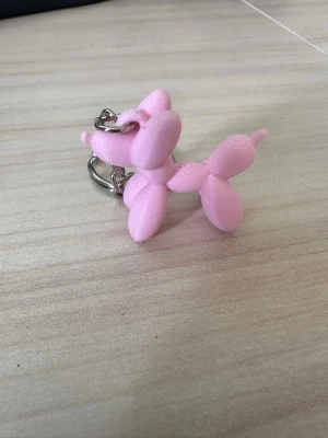 Nyckelring ballonghund rosa - Säljer en söt nyckelring med en ballonghund i ljusrosa plast. Ballonghunden har en lekfull design och sitter fast i en metallring. Perfekt att hänga på väskan eller nyckelknippan för en rolig detalj.
