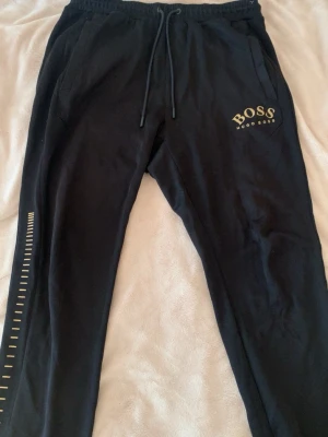 Svarta mjukisbyxor - HUGO BOSS - Säljer ett par snygga  svarta mjukisbyxor från HUGO BOSS i storlek M💕byxorna har sidofickor & en backficka, byxorna är i topp skick me noll defekter🪷 meddela mig vid frågor, fler bilder eller diskutera pris!!💌