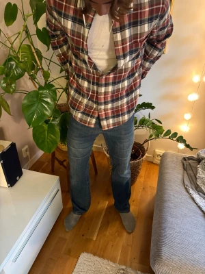 *bootcut* Armani jeans - Säljer ett par klassiska blå jeans med rak passform och broderade detaljer på bakfickorna. Jeansen har normal midja och är tillverkade i ett slitstarkt denimtyg. Perfekta för en avslappnad och stilren look. Storlek 32