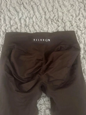 Bruna seamless leggings från Relode - Snygga bruna seamless leggings från Relode med låg midja och tight passform. Tillverkade i stretchigt material som sitter skönt och formar sig efter kroppen. Perfekta för träning eller chill dagar.