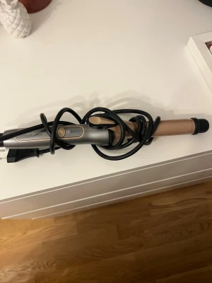 Locktång i guld och svart - Säljer en locktång i snygg guld- och svartfärg med sladd. Perfekt för att fixa lockar eller vågor i håret. Handtaget har en knapp och en indikatorlampa. Passar dig som vill styla håret snabbt och enkelt. Pris kan diskuteras 