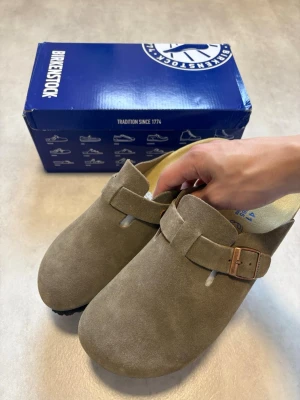 Birkenstock Boston Gray Green Strl 41 – Mycket fint skick - Säljer ett par Birkenstock Boston i färgen Gray Green, storlek 41. Endast använda inomhus och i mycket fint skick. Inga brister eller tydliga användningsspår.  Perfekta inför hösten! 🍂  Vid frågor eller bud är det bara att skriva! 😊