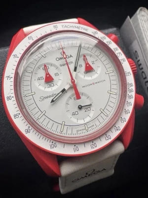 Omega x Swatch Speedmaster MoonSwatch - Snygg Omega x Swatch Speedmaster MoonSwatch med röd boett och vita detaljer. Klockan har vit urtavla med röda visare och tachymeter-skala runt glaset. Kommer med vitt textilband med Omega-logga. Perfekt för dig som gillar ikoniska samarbeten.