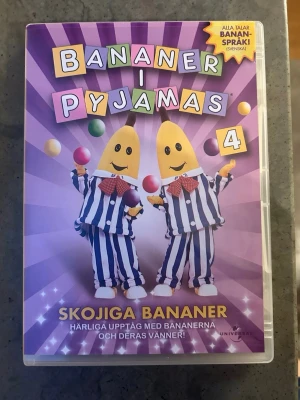Bananer i pyjamas DVD - DVD-skiva med ”Bananer i Pyjamas - Skojjiga Bananer”. Innehåller 10 avsnitt. Cirka 51 minuter.  Finns på språk: Svenska, Danska, Norska, Finska    OBS!! skivorna är begagnade så det kan förekomma repor/hairlines på skivorna, men då jag kollar igenom alla filmer jag säljer garanterar jag att alla funkar felfritt om inget annat står! :)