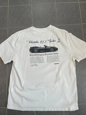 Vit Porsche 911 Turbo S t-shirt - Säljer en vit t-shirt med tryck av en Porsche 911 Turbo S och texten. Med storleken S.
