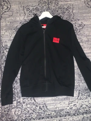 Hugo Ziphoodie - Säljer min Hugo hoodie då den är för liten för mig, skicket e som ny knappt använd ens, hör av er för fler frågor o funderingar! Pris kan diskuteras!