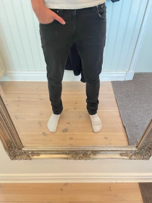 Svarta nudie jeans - Slimfit nudie jeans i svart färg. Riktigt snygga med en lite ljusare färg åt det gråare hållet. Modellen är 183, storlek 28/32. Modell Lean Dean misty ridge. Hör av er vid funderingar!