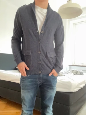 Mörkgrå kofta - Stilren mörkblå kofta. Koftan  och bruna armbågslappar i mocka som ger en snygg kontrast. Perfekt till jeans och t-shirt för en avslappnad look.                                                     Kom pm för frågor!!!