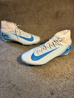 Nike air zoom fotbollsskor blå vita  - Säljer ett par Nike air zom. Ett par ass skysta fotbollsskor som är riktigt snygga och sköna att spela i. Jag har använt de i en halv säsong efter de har de bara stått. Så de är i sjukt bra skick man ser att de är använda för färgen på de vita har ändrat sig pytte lite men inget man märker från lite avstånd annars så är de som nya .         Om du har några funderingar är de bara att höra av sig.🔥
