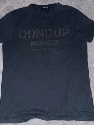 Svart t-shirt från Dondup - Snygg svart t-shirt från Dondup med tryck framtill där det står 'Dondup MCMXCIX Made in Italy'. Klassisk passform och rund halsringning. Tillverkad i mjuk bomull som känns skön mot huden. Perfekt till jeans eller shorts.