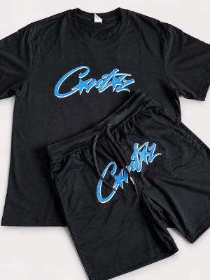  Cortiez Svart set med blått tryck  - Snyggt svart set med t-shirt och shorts. Båda plaggen har ett stort blått och vitt grafiskt tryck med texten 'Cortiez' på bröstet och benet. T-shirten har rund hals och shortsen har dragsko i midjan. Perfekt för en avslappnad och trendig look.