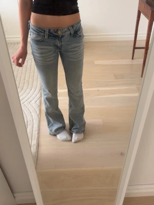 Ljusblå lowwaist bootcut jeans - Säljer ett par ljusblå lowwaist bootcut jeans. Dom är lite skitiga och slitna där nere men jag skulle inte säga att de är jätte tydligt. Pris går att diskutera.