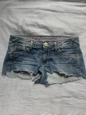 Blå jeansshorts w24 - Säljer ett par blå jeansshorts med slitningar. Shortsen är lågmidjade och har nitar på bakfickorna. Perfekta för sommaren och ger en avslappnad vibe. Det är barnstorlek men sitter som xs/w24. Pris kan diskuteras.💕
