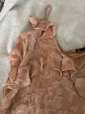 Rosa/aprikosfärgad topp från ZARA - Säljer en superfin linnetopp från ZARA med tunna axelband och volangdetaljer. Har kortat ner banden lite eftersom Zaras band är väldigt långa💗 knappt använd