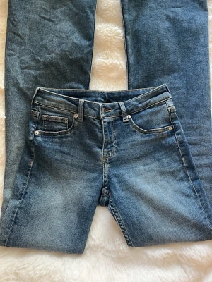 Blå jeans från H&M Divided - Snygga blå jeans från H&M Divided i klassisk femficksmodell. Jeansen har normal midja, raka ben och är tillverkade i ett mjukt denimtyg med lätt slitningar framtill. Perfekta till en avslappnad look och passar till det mesta.