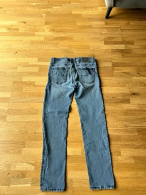 Blå jeans från Jacob Cohen - Säljer ett par klassiska blå jeans från Jacob Cohen. Jeansen har raka ben, fem fickor och snygga detaljer vid linningen. Materialet är mjukt och stretchigt för extra komfort. Perfekta för dig som gillar en avslappnad men ändå stilren look.