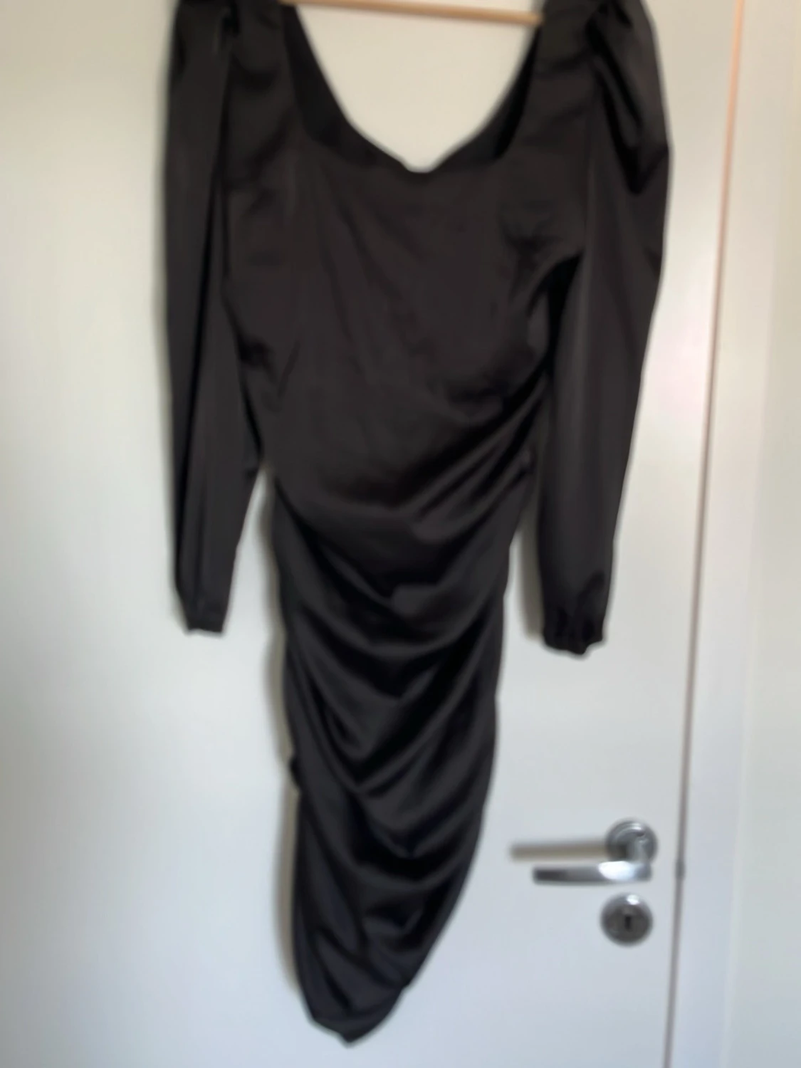 Svart långärmad draperad klänning