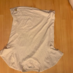 Vit t-shirt från Lyle & Scott - Klassisk vit t-shirt från Lyle & Scott med den ikoniska gula loggan broderad på bröstet. T-shirten har rund halsringning och korta ärmar. Perfekt basplagg till garderoben och enkel att matcha med allt.