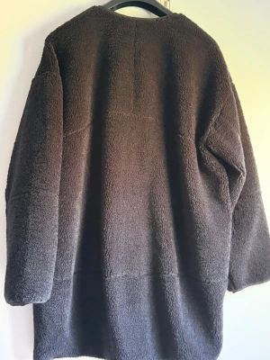 Svart teddyjacka från Lululemon - Mysig svart teddyjacka från Lululemon i oversized modell. Tillverkad av 70% polyester och 30% återvunnen polyester, med mjuk och fluffig textur. Perfekt för kalla dagar när du vill ha både stil och komfort.