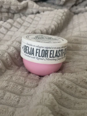 Beija Flor Elasti-Cream mini - Säljer en liten burk Beija Flor Elasti-Cream från Sol de Janeiro. Krämen kommer i en rund, rosa plastburk med vitt lock och svart text. Den är helt oanvänd och endast öppnad. 