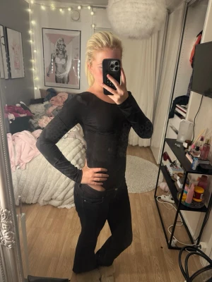 Svart långärmad body med öppen rygg - Säljer en svart långärmad body med tight passform och öppen rygg. Bodyn  är enkel men ändå snygg och passar perfekt till jeans eller kjol. Materialet känns mjukt och stretchigt, vilket gör den bekväm att bära hela dagen.