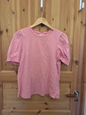 Ljusrosa puffärm topp - Söt ljusrosa topp med puffärmar och rund halsringning. Tillverkad i mjukt bomullsliknande material som känns bekvämt mot huden. Perfekt för dig som gillar en enkel men trendig stil med feminina detaljer.