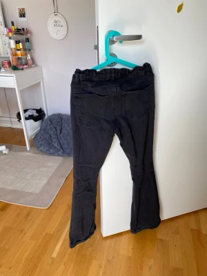Svarta jeans från Lindex, storlek 158 - Säljer ett par svarta jeans från Lindex i storlek 158. Jeansen har två bakfickor och resår i midjan för extra komfort. Perfekta till en avslappnad och cool stil. Passformen är normal och materialet känns mjukt och följsamt.