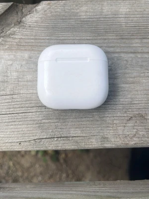AirPods 4 - Säljer ett par AirPods 4. Hörlurarna har en stilren och kompakt design med mjuka former och svarta detaljer. Perfekta för musik, poddar och samtal på språng. Laddfodralet är smidigt att ta med överallt. Äkta!
