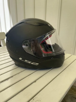Mopedhjälm - Välanvänd men fullt funktionell mattsvart mopedhjälm från LS2, modell: LS2 rapid. Ny tvättade avtagbara delar från insidan (se sista bilden). Framträdande märken på hjälmen, framförallt vänstersidan (se bild), men knappt några repor på hjälmen. Storlek XS, 53-54 cm. 