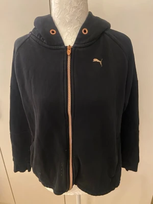 Svart hoodie med dragkedja från Puma - Svart hoodie från Puma med dragkedja. Storlek XS. Använd flera gånger, lite sliten och fläckar se bild 4,5.