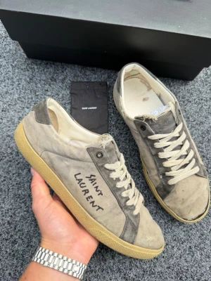 Saint laurent skor  - Säljer dessa magiskt feta saint laurent sneakers. Denna modell är en av de mest sällsynta. Size 43,5. Skick 6,5/10, dom är limmade längst fram på ena skon. Box+ påse ingår. Nypris 7200kr, skorna har slutat tillverkas vilket gör de extremt efterfrågade. Går ner i pris vid snabb affär! Fraktar inom 24H! ⚡️