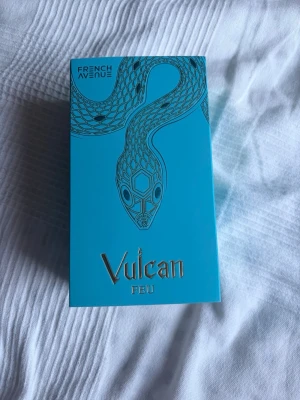 Vulcan Feu parfym French Avenue byte/sälj - Unik parfym från French Avenue, Vulcan Feu. Flaskan är turkos med gulddetaljer och har ett coolt orm-motiv både på asken och flaskan. Locket är dekorerat med mönster och en guldfärgad orm som slingrar sig runt toppen. Perfekt för dig som gillar snygg design. Ungefär 90ml kvar. Hör gärna av en om ni vill byte och kontakta gärna innan om ni vill köpa. Ni får självklart ge egna prisförslag 