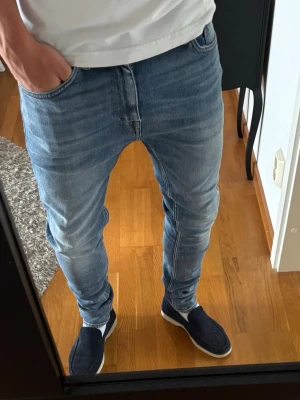 Ljusblå slim fit jeans Tiger of Sweden - Snygga ljusblå slim fit jeans från Tiger of Sweden. Klassisk femficksmodell med normal midja och smal passform hela vägen ner. Jeansen har en stilren look och är tillverkade i mjukt denimtyg som ger en bekväm känsla. Perfekta för en trendig och avslappnad stil.