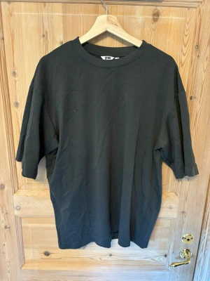 Svart oversized  Airism t-shirt från Uniqlo U - En svart oversized t-shirt från Uniqlo U i storlek L. Tillverkad i mjuk bomull med klassisk rund hals och korta ärmar. Enkel och clean design som passar perfekt till jeans eller shorts.
