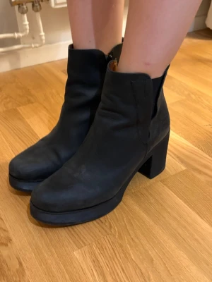 Svarta höstboots - Svarta kängor i storlek 41 perfekta för hösten. Skorna har en tjock klack på 5cm och 2cm hög sula. Knappt använda och i väldigt bra skick. Märket är tyvärr okänt.